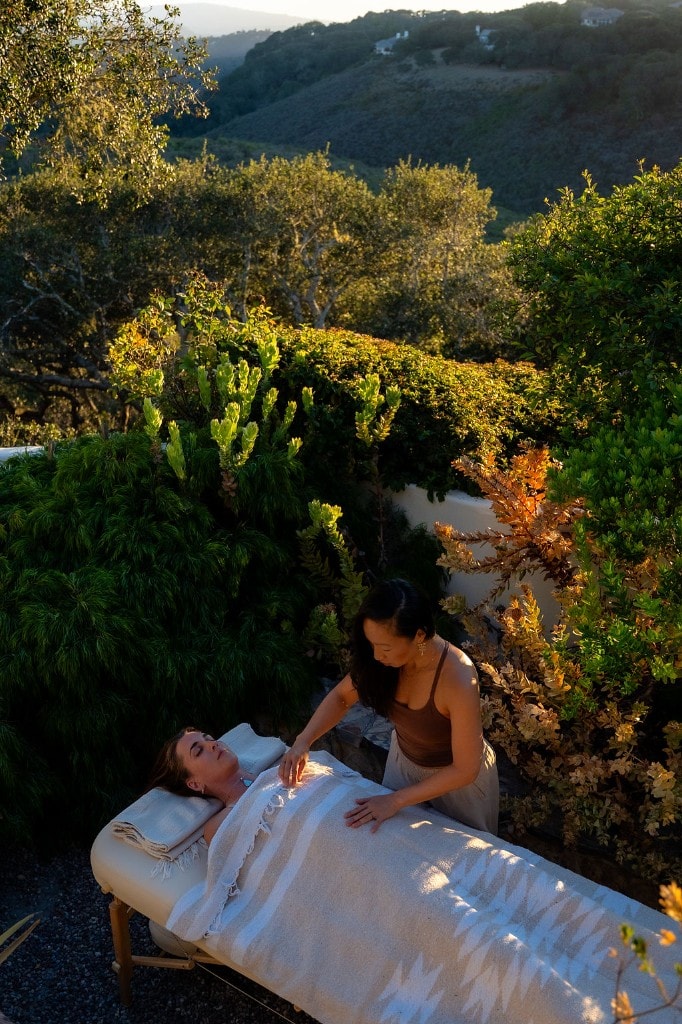 Victoria offering energy healing outdoors at golden hour, hands above a client