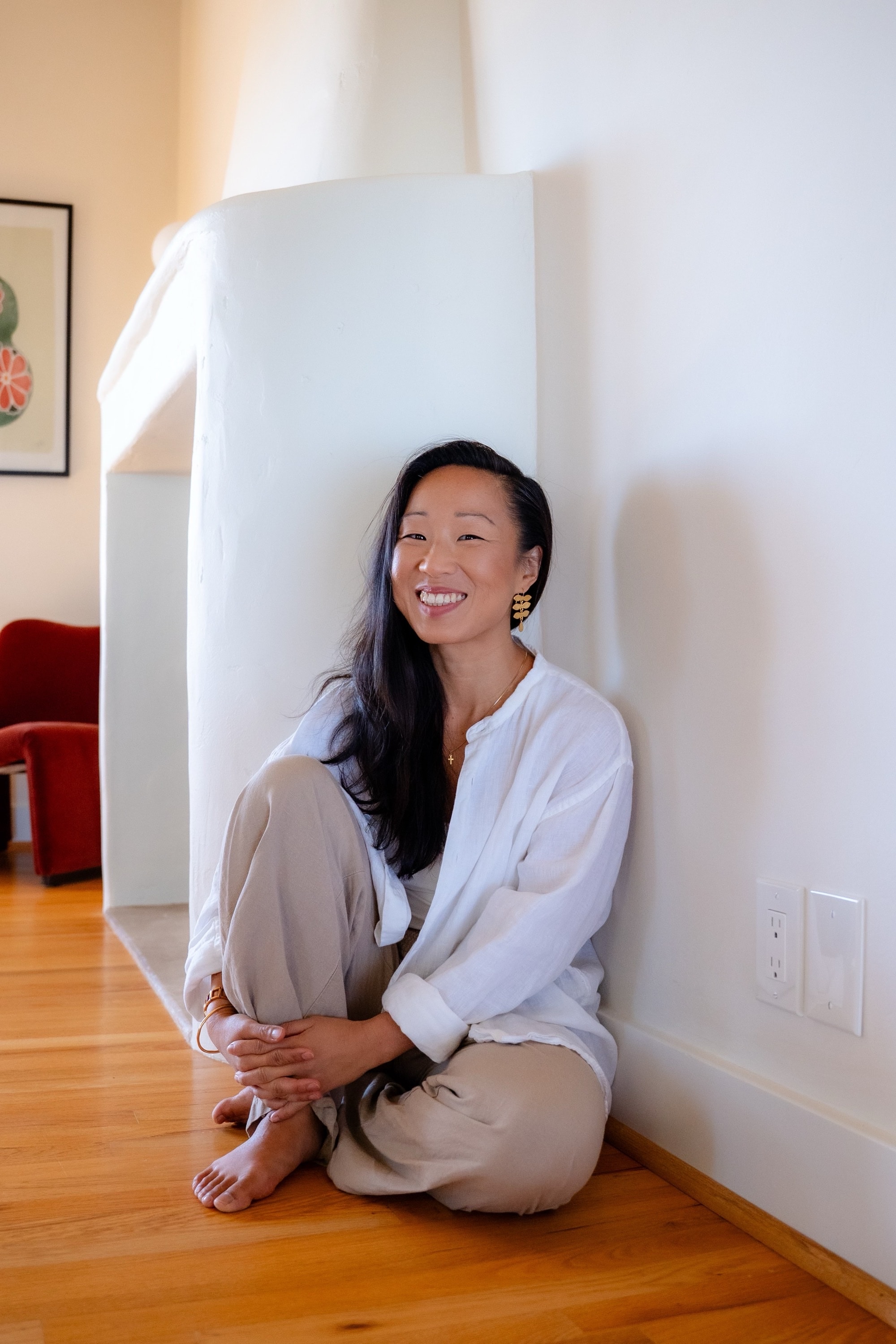 Victoria Grace seated against a white wall, smiling